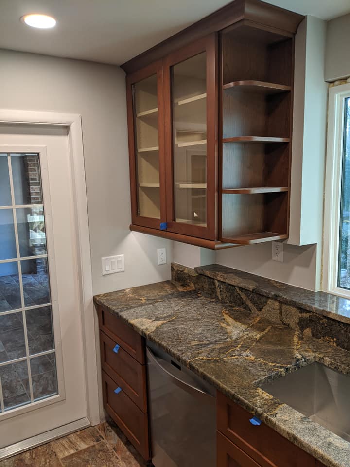 A kitchen with stainless steel appliances , granite counter tops , and wooden cabinets.