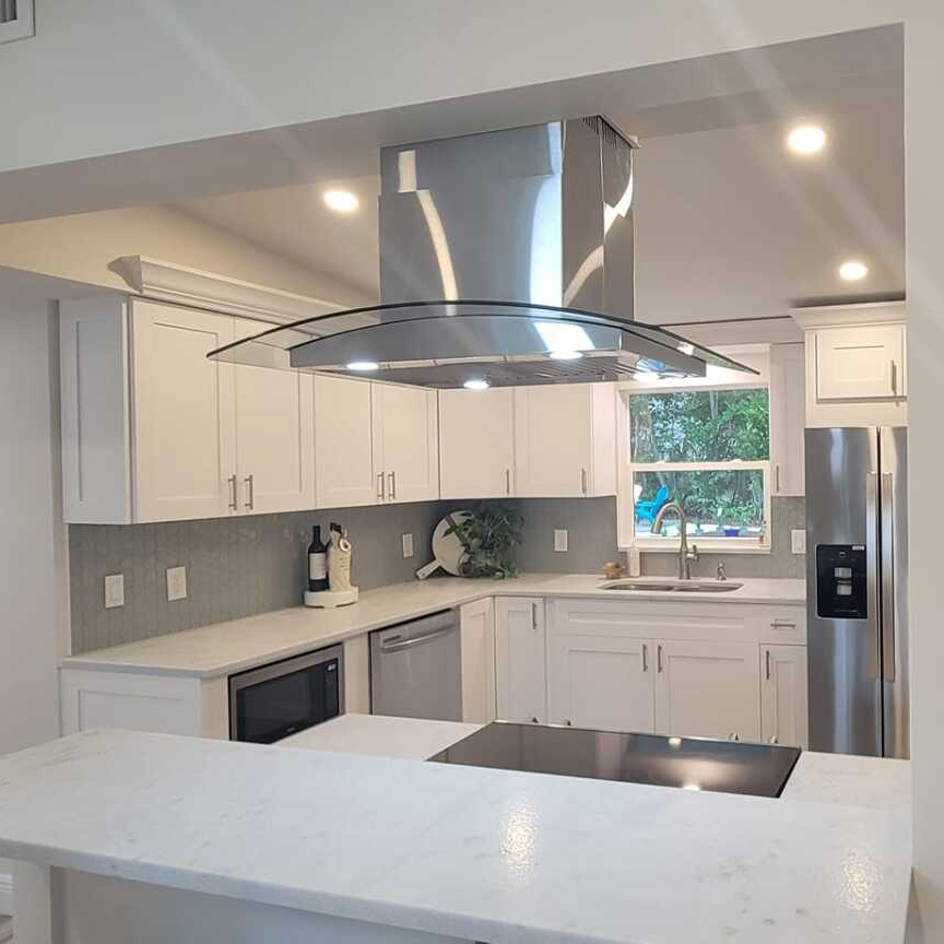 A kitchen with white cabinets and stainless steel appliances