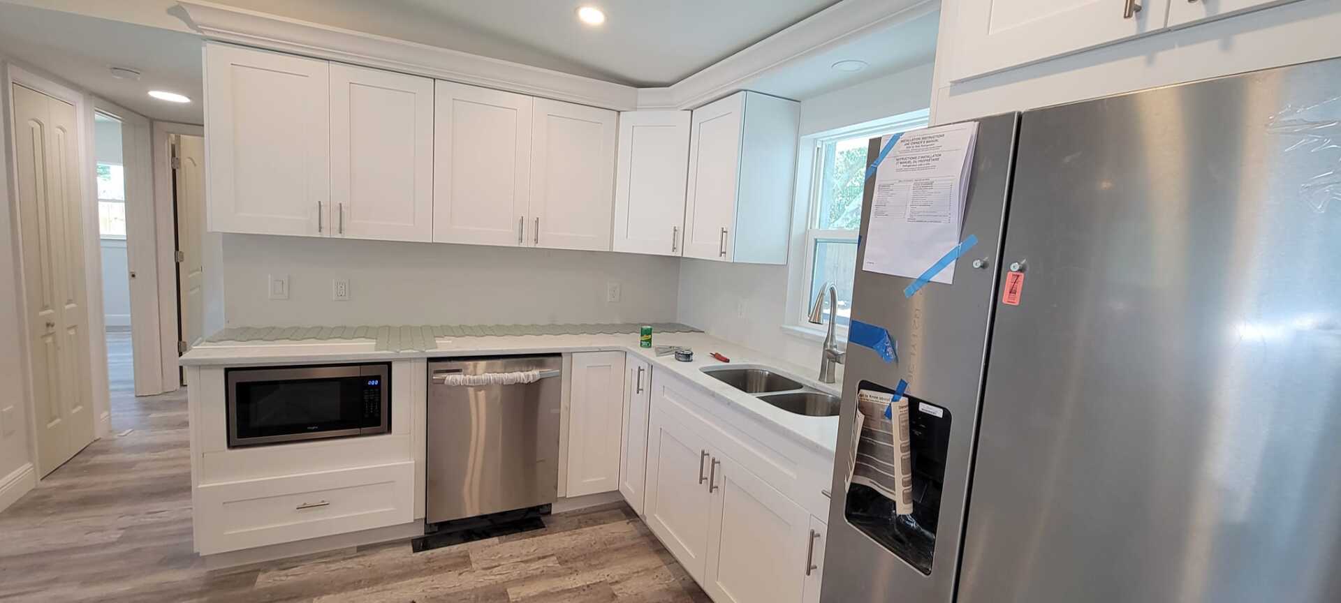 A kitchen with white cabinets and stainless steel appliances.