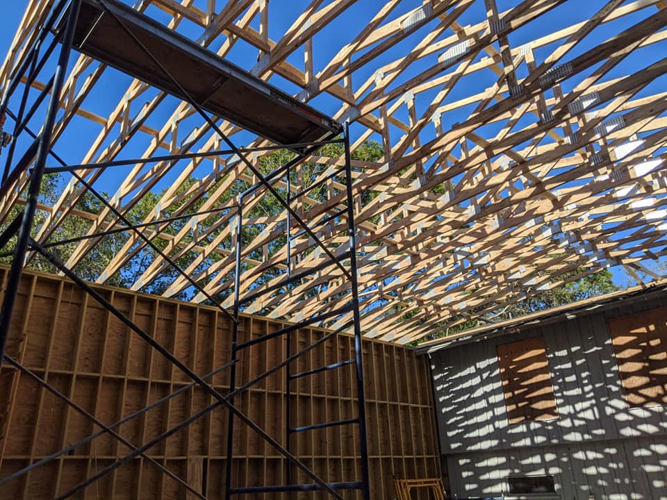 A large wooden structure under construction with a scaffolding in the foreground