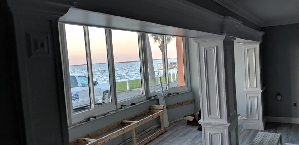 A room with a lot of windows and a view of the ocean.