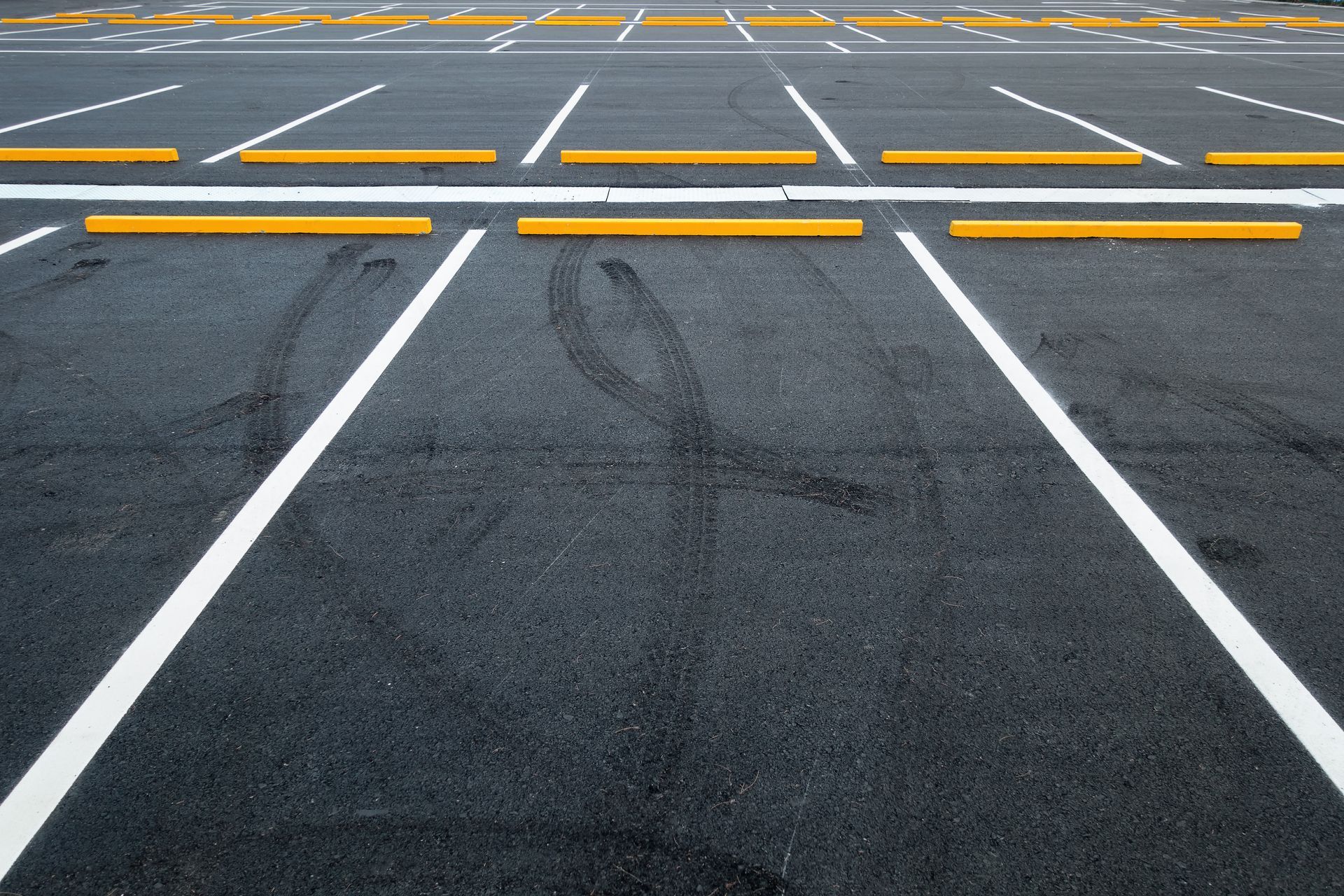 A parking lot with yellow and white lines and yellow curbs.
