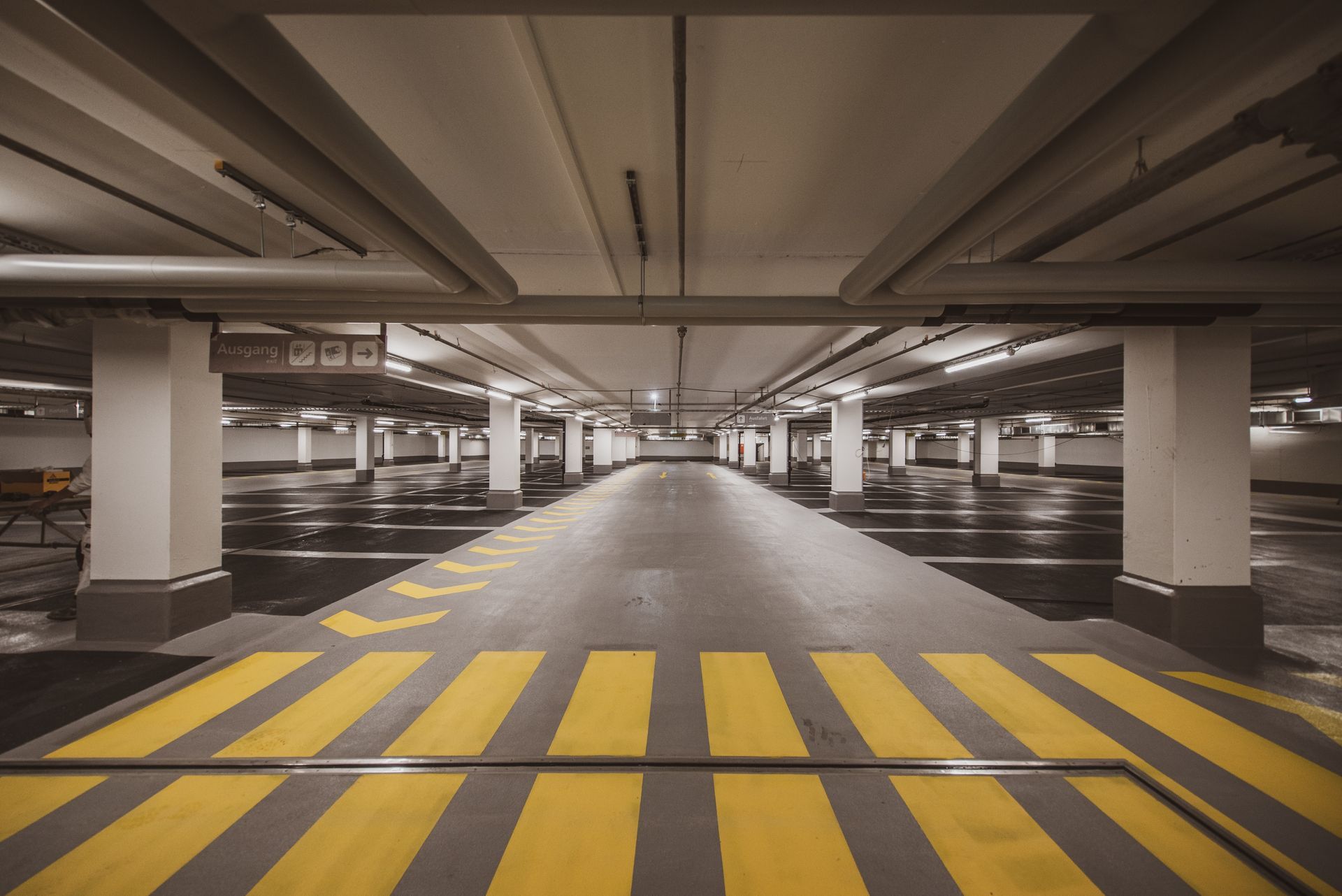 An empty parking garage with yellow and black stripes on the floor.