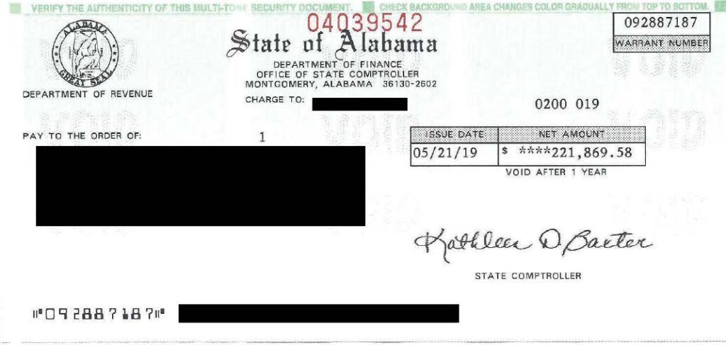 Black-and-white Alabama state check with seals, handwritten signature, and redacted account details
