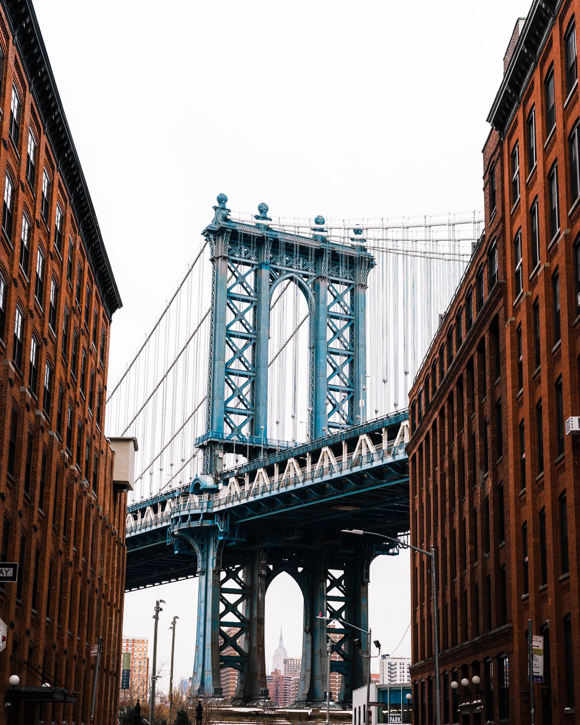 Manhattan Bridge framed by red brick buildings in New York City.
