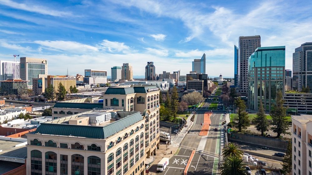 Downtown city skyline with modern buildings along a broad street on a sunny day