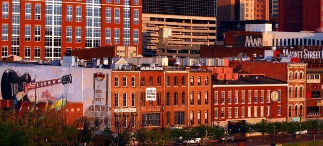 Row of red-brick historic buildings in a city skyline at sunset
