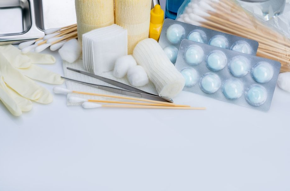 Assorted manicure tools, cotton pads, nail files, and polish colors on a light surface