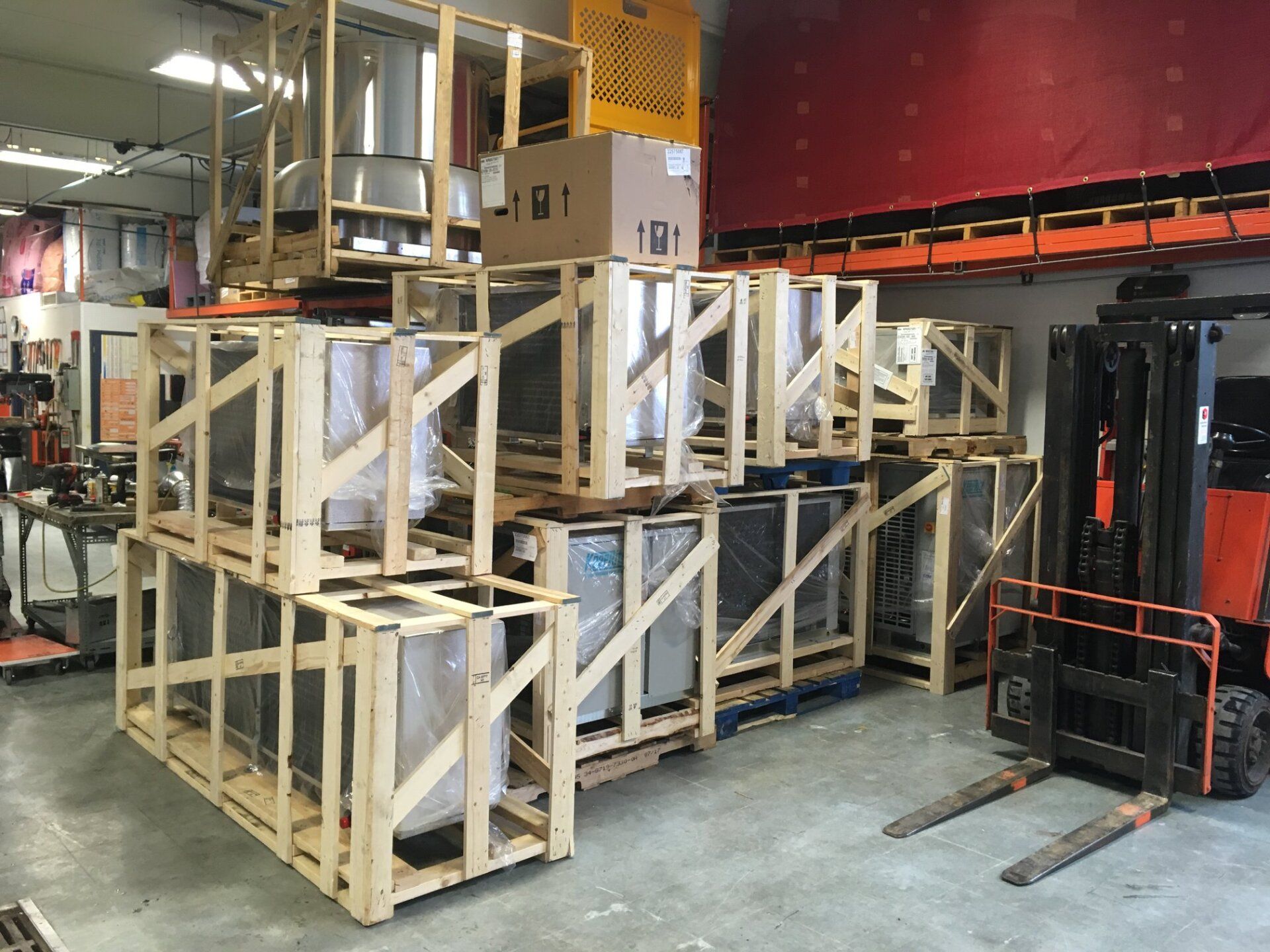 Un chariot élévateur transporte des caisses en bois dans un entrepôt.