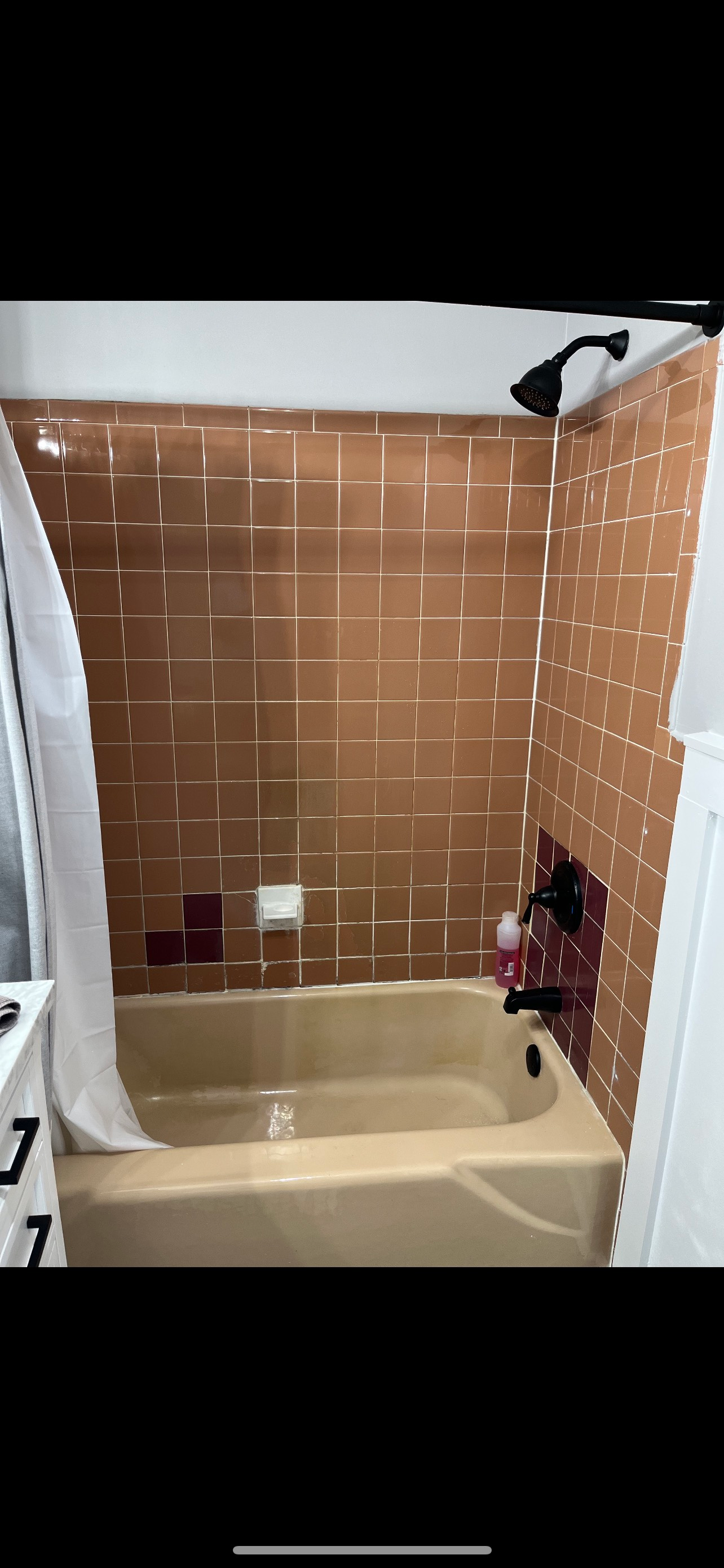 A bathroom with a tub and a shower with copper tiles.
