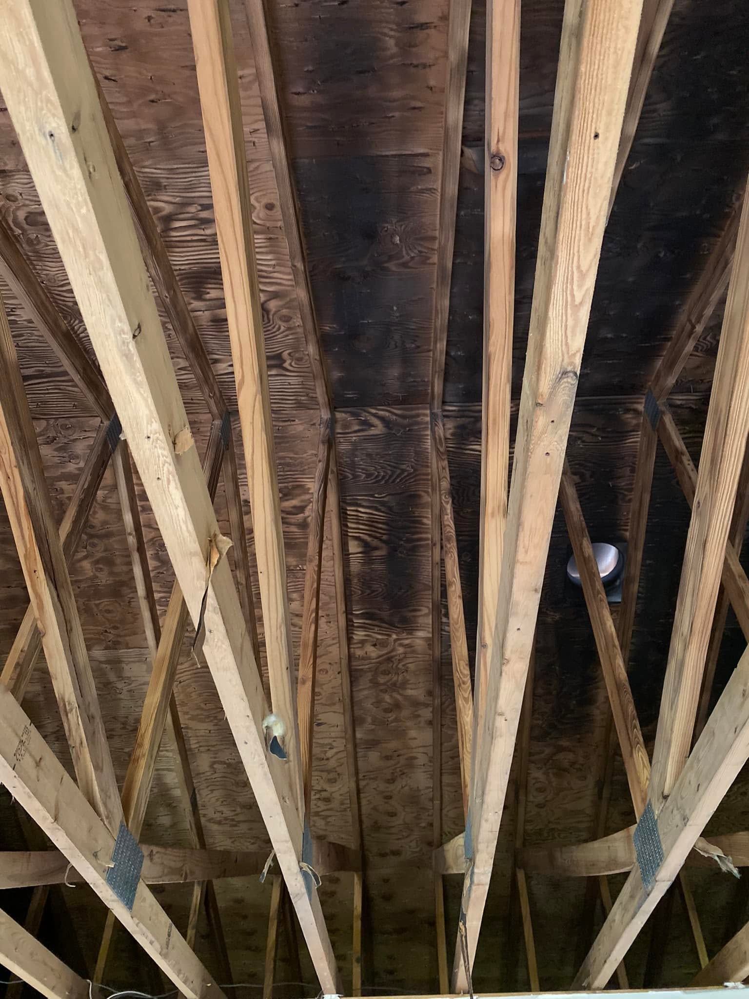 Exposed wooden roof rafters and dark beams viewed from below