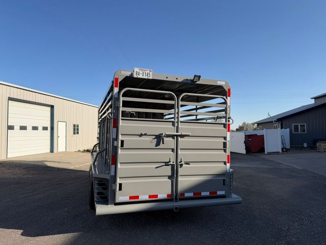 Rear view of a livestock trailer parked in an industrial lot under a clear blue sky