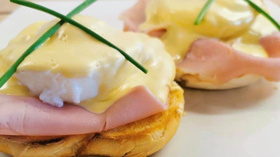 Open-faced ham and poached egg sandwiches topped with hollandaise and chives