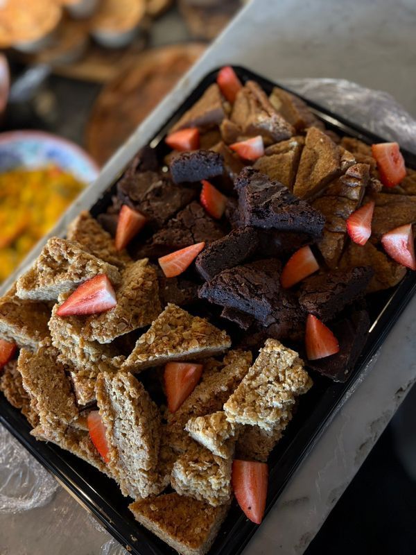 Tray of layered chocolate dessert topped with strawberry pieces and dark chocolate drizzle