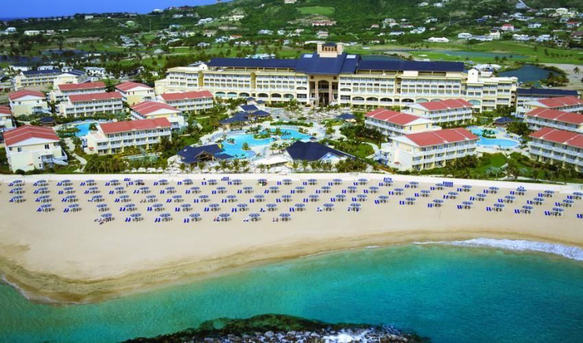 An aerial view of st. kitts marriott beach resort with lots of umbrellas