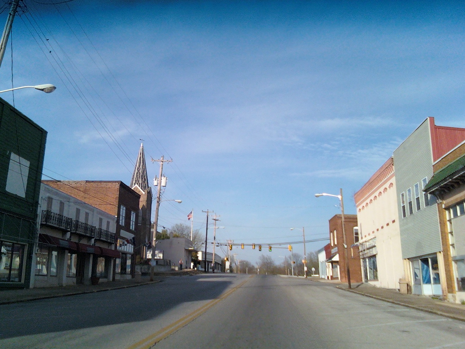 Empty small-town street with buildings on both sides under a blue sky