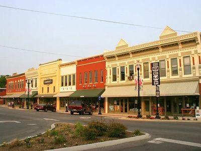 Colorful historic storefronts line a quiet downtown street at dusk