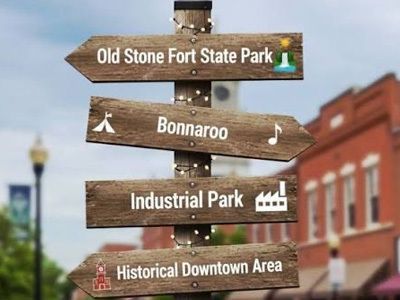 Wooden directional signs for Old Stone Fort State Park, Bonnaroo, Industrial Park, and Historical Downtown Area.