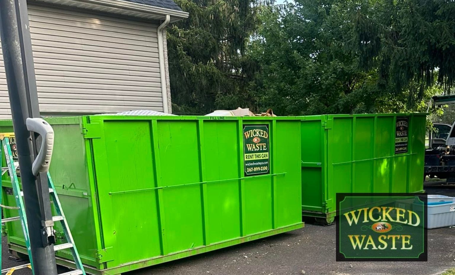 Bright green waste dumpster beside a house, with a “Wicked Waste” sign on the front.