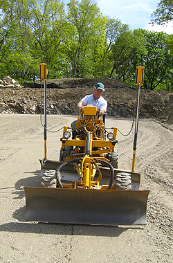 a man is driving a yellow bulldozer on a dirt road