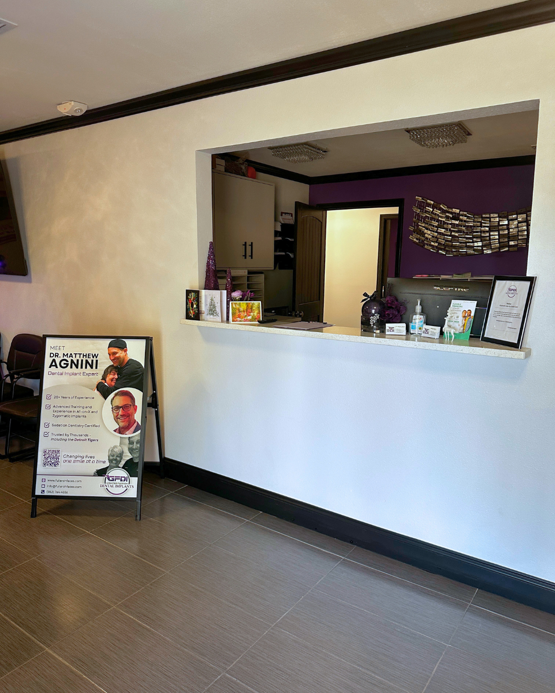 Reception area with a white counter and sign. Doorway in the background.