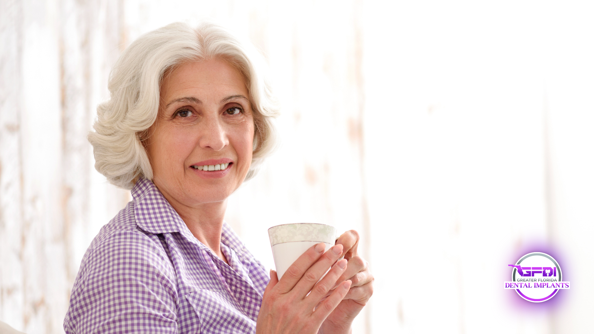 Smiling woman in a purple checkered shirt holding a mug against a bright background