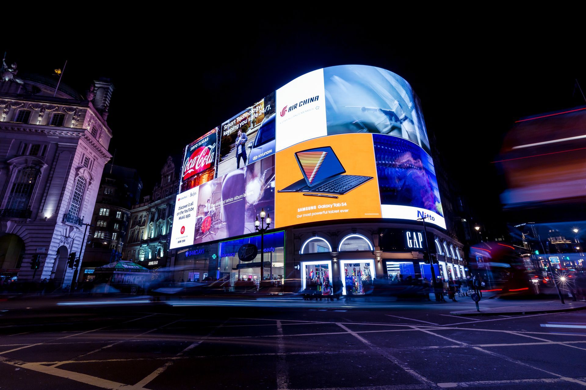 A large billboard on the side of a building at night.