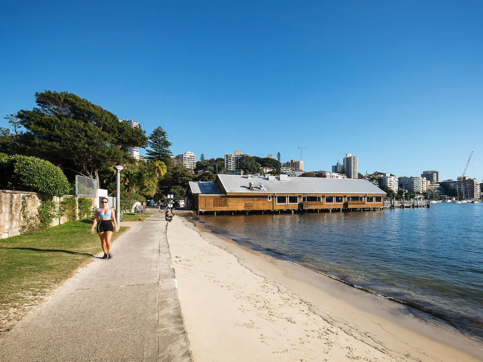 a woman is walking along a path next to a body of water .