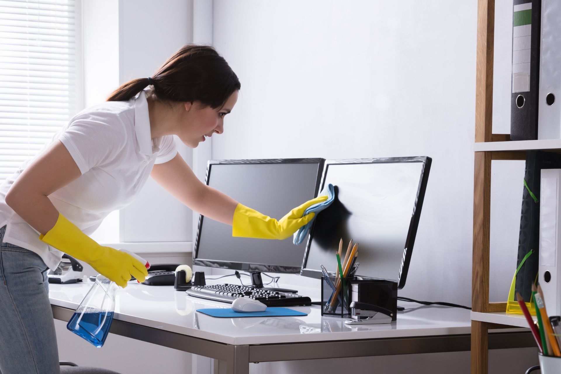 woman cleaning computer screen