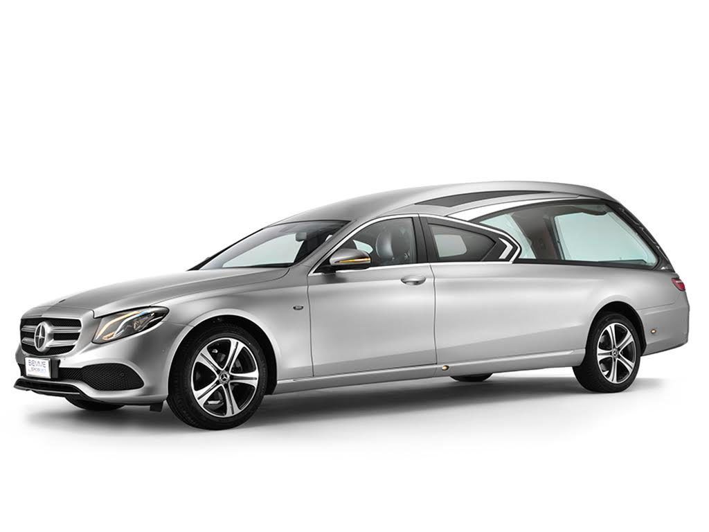Un carro funebre Mercedes-Benz color argento, inclinato verso sinistra, su sfondo bianco.