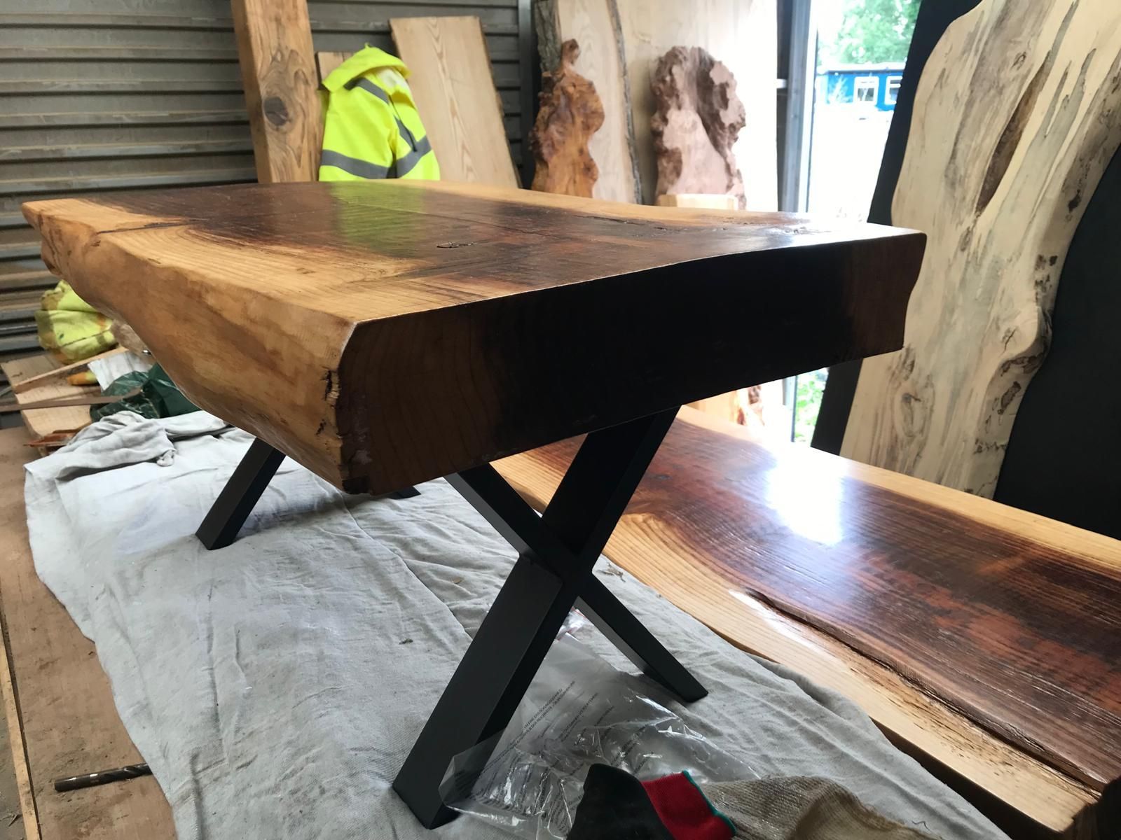 A wooden table with metal legs is sitting on a white cloth.