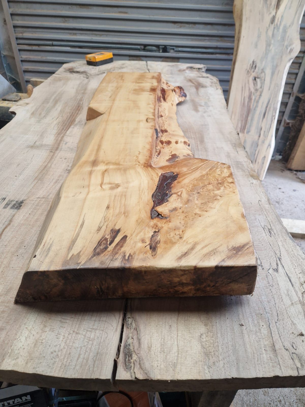 A piece of wood is sitting on top of a wooden table.