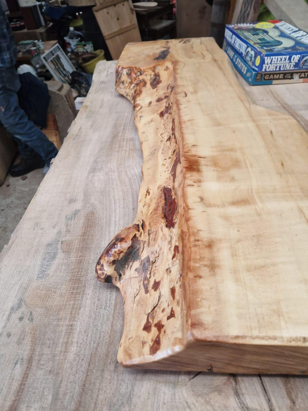 A large piece of wood is sitting on top of a wooden table.