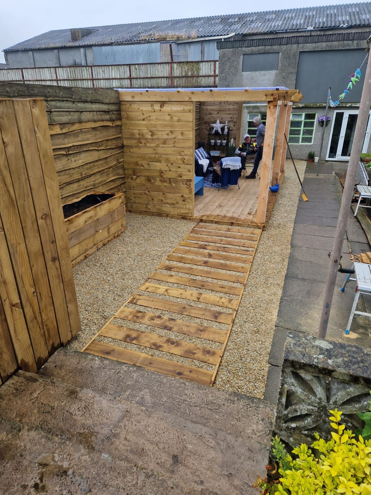 A wooden shed is being built in a backyard.