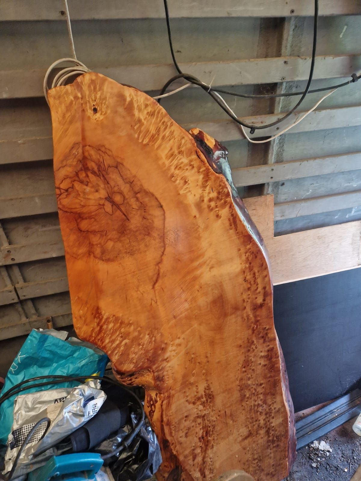 A large piece of wood is hanging from a wire in a room.