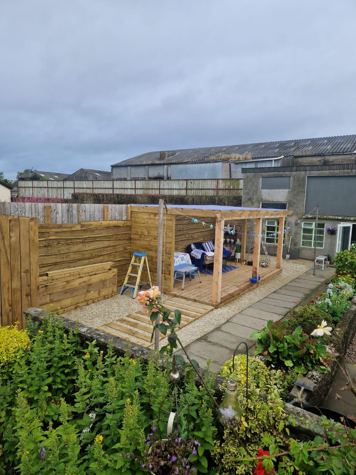 A wooden pergola is being built in a backyard.