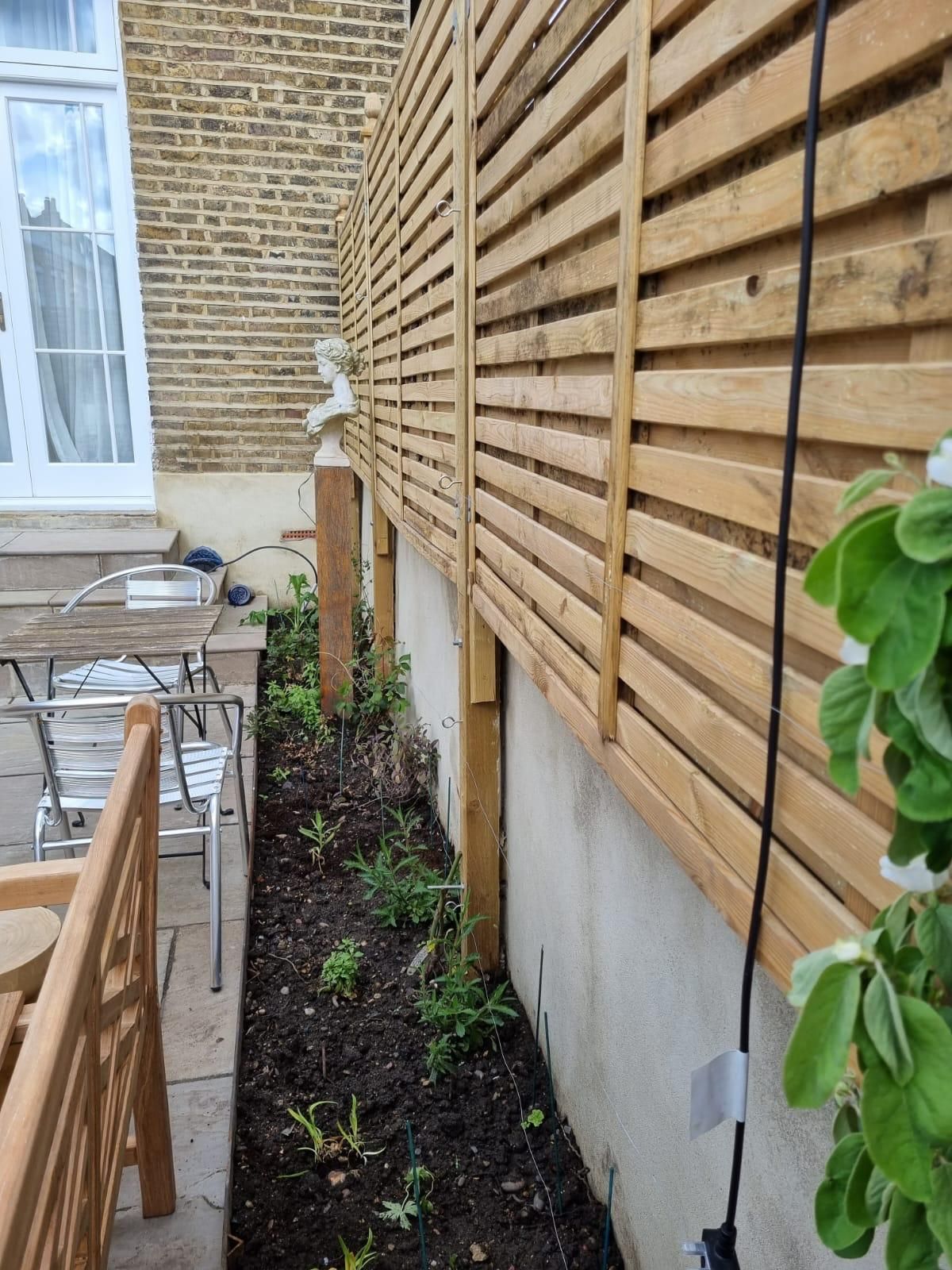 A wooden fence along the side of a house