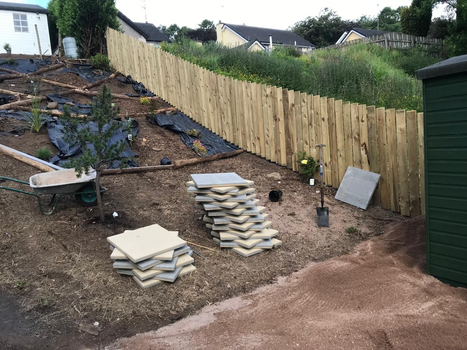 A wooden fence is being built in a garden.