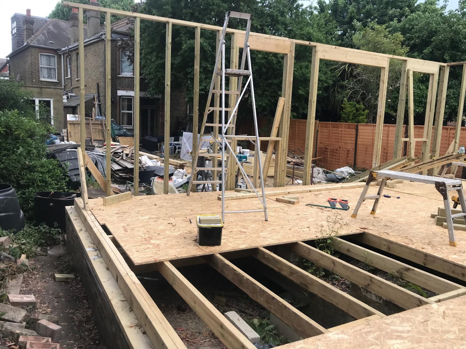 A ladder is sitting on top of a wooden structure under construction.