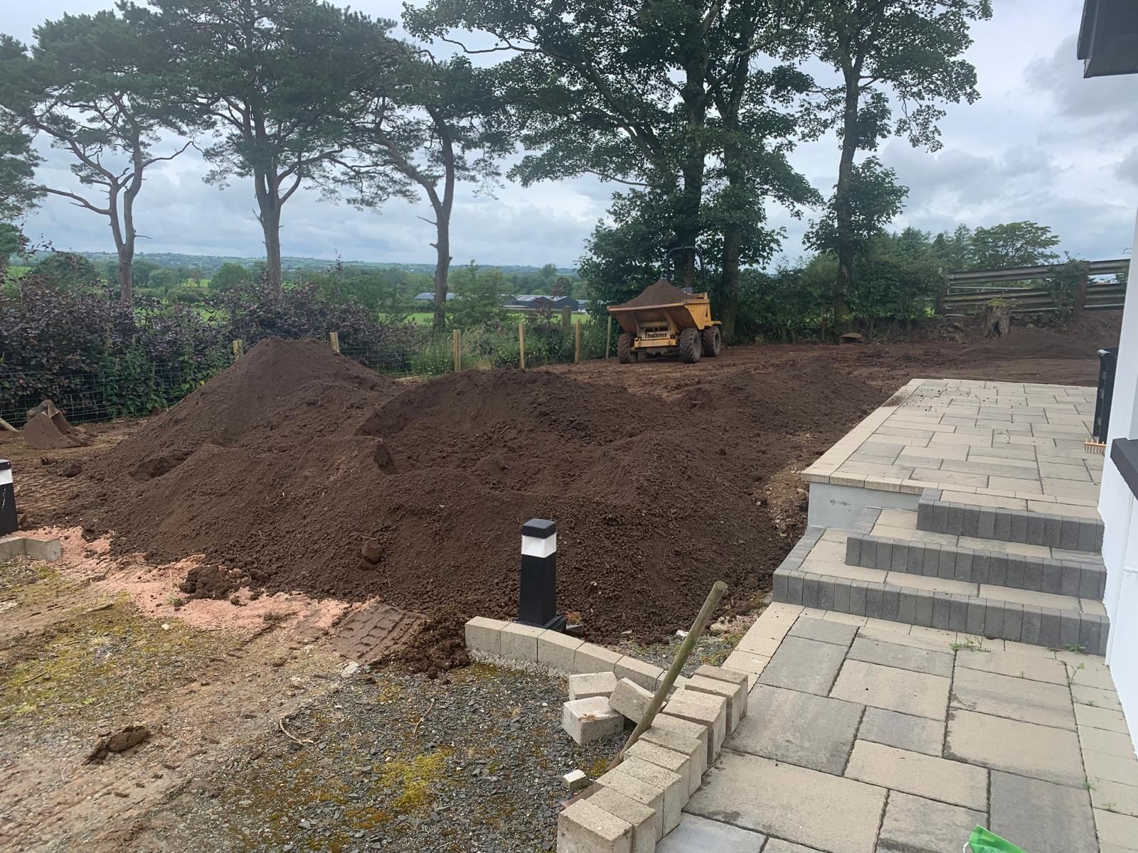 A large pile of dirt is sitting in front of a house.