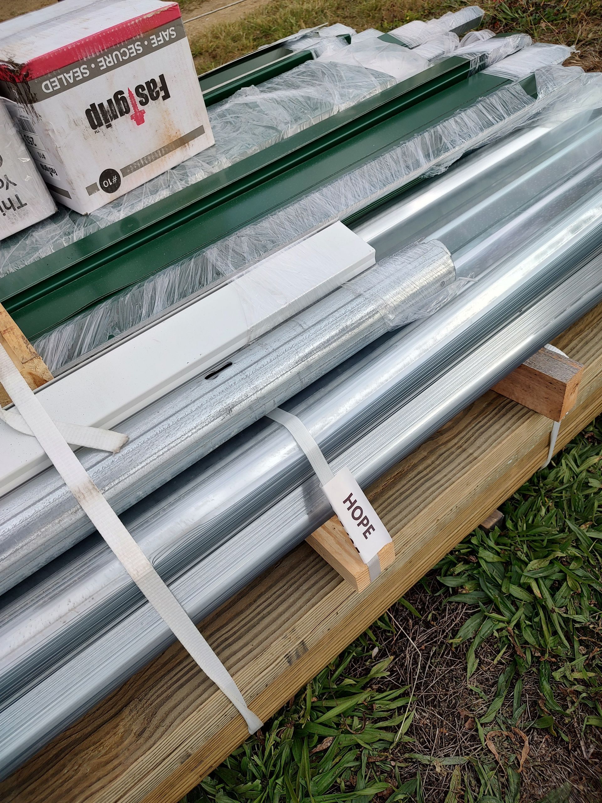 Contact us to donate supplies and skills! A bunch of metal pipes are sitting on top of a wooden pallet.