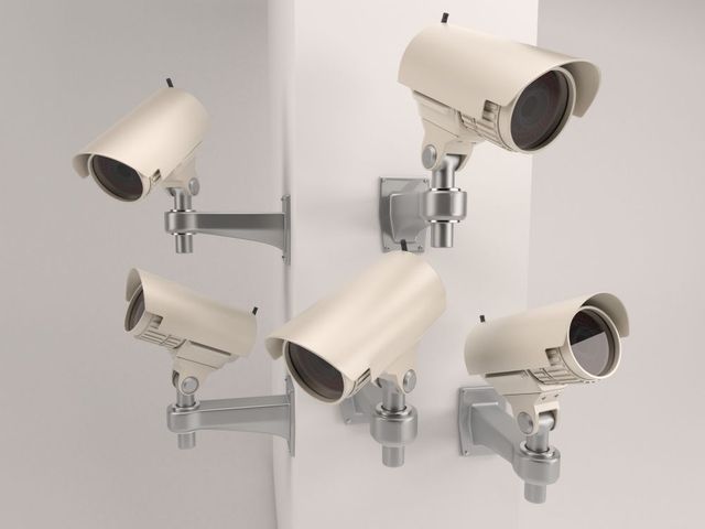 A group of security cameras are hanging on a wall.