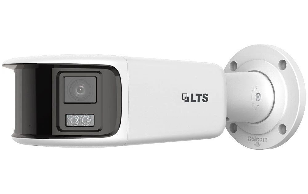 A white and black security camera is mounted on a wall.