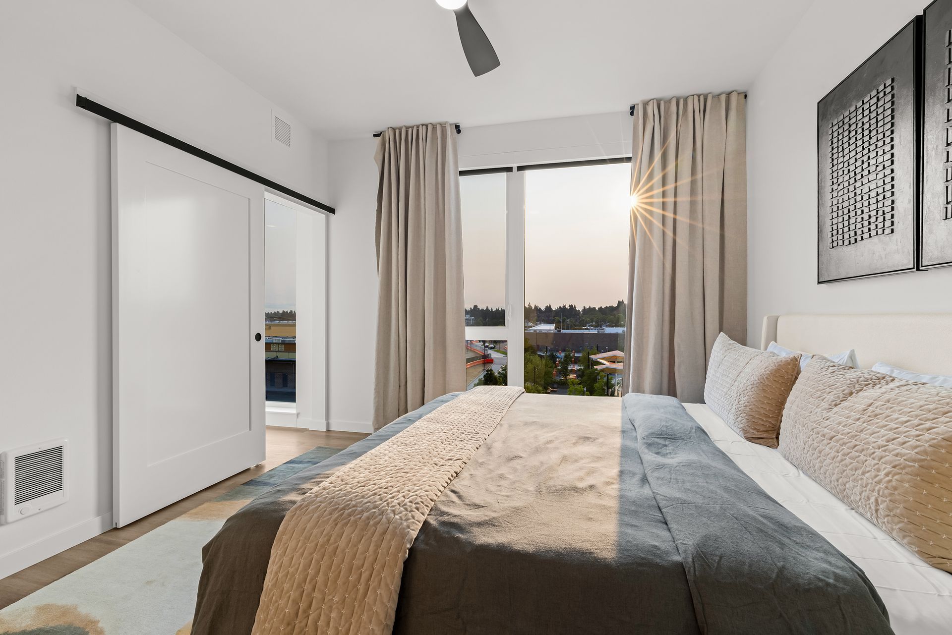 Bright modern bedroom with a bed, sliding closet doors, and a window overlooking the outdoors