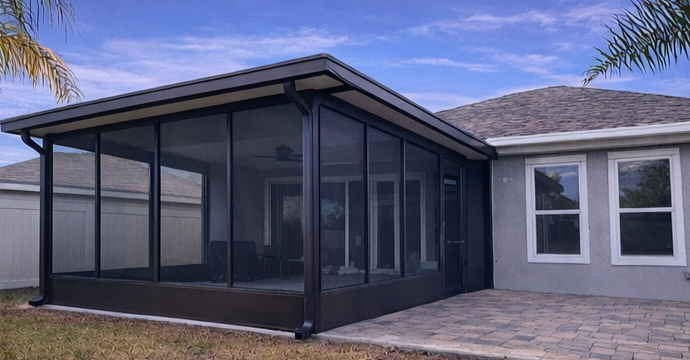 Screened patio enclosure attached to a gray house with stone pavers and a tiled roof. Screened patio enclosure attached to a gray house with stone pavers and a tiled roof.