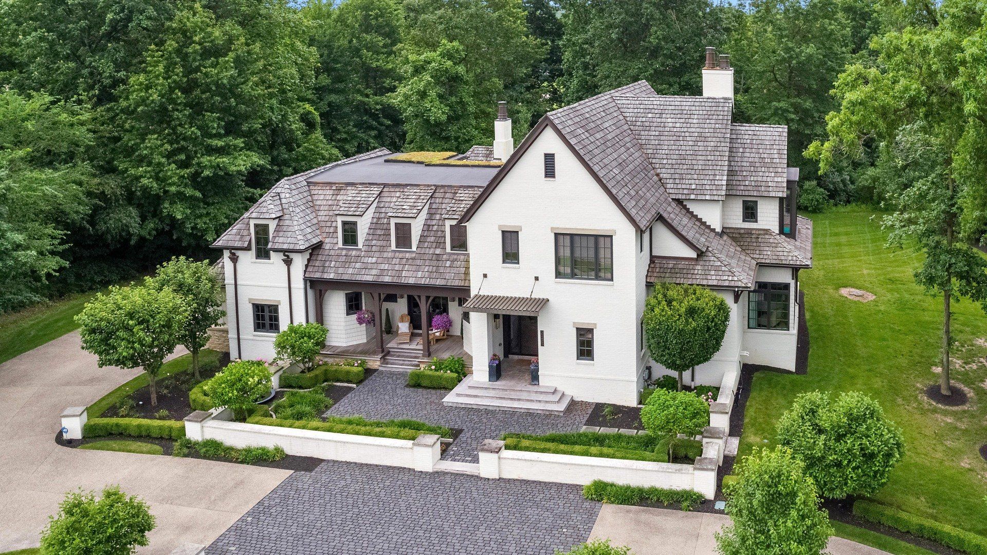 An aerial view of a large white house surrounded by trees