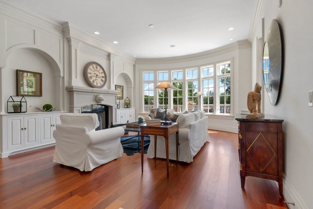 A living room with a fireplace and a clock on the wall