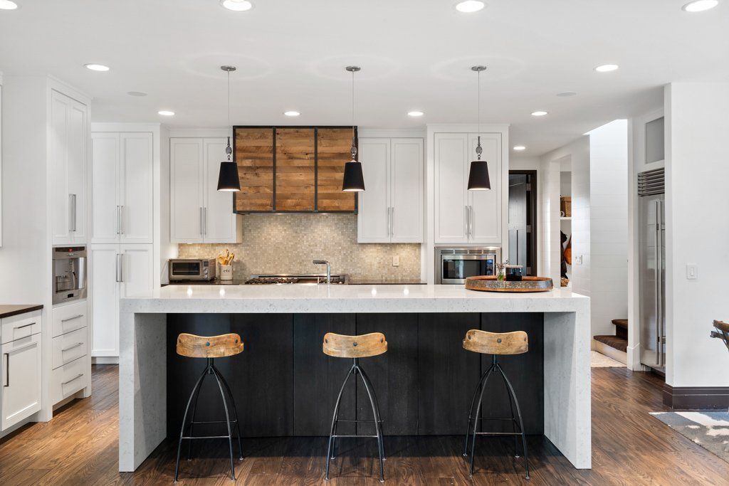 A kitchen with a large island and three stools