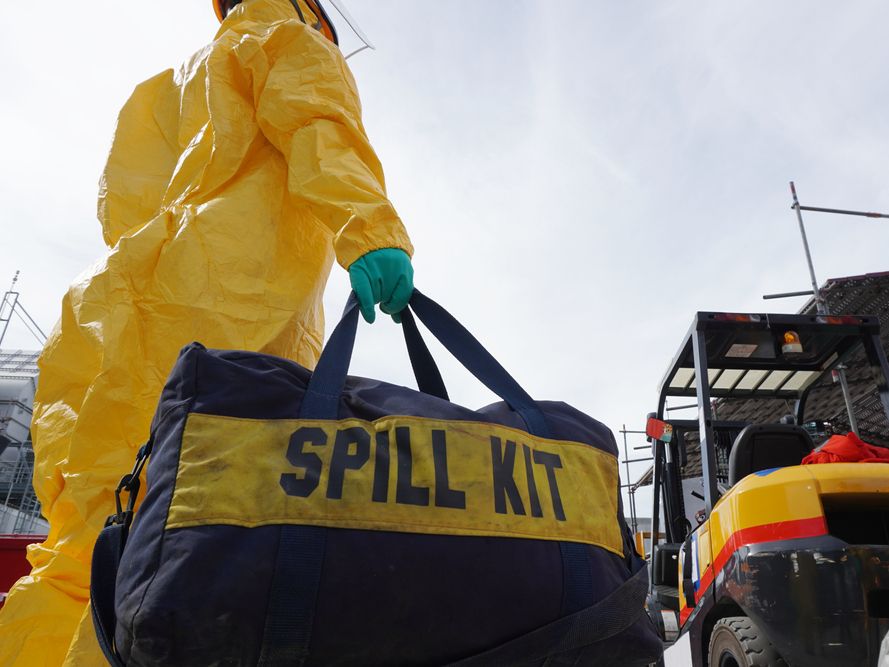 Person in yellow hazmat suit holding