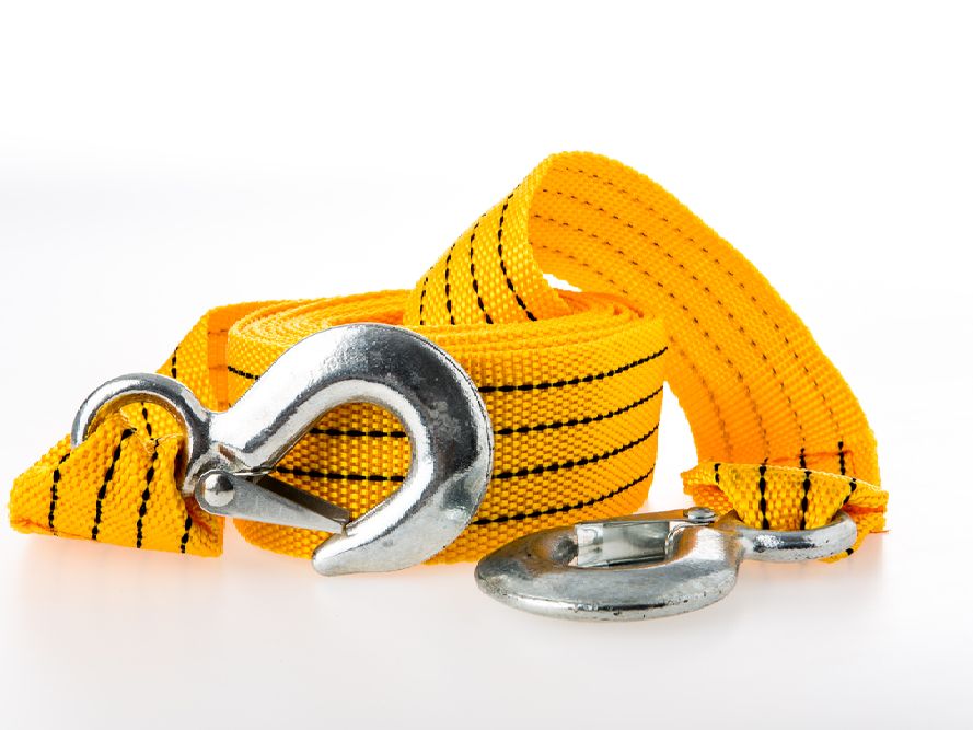 Yellow tow strap with metal hooks, coiled on white background.